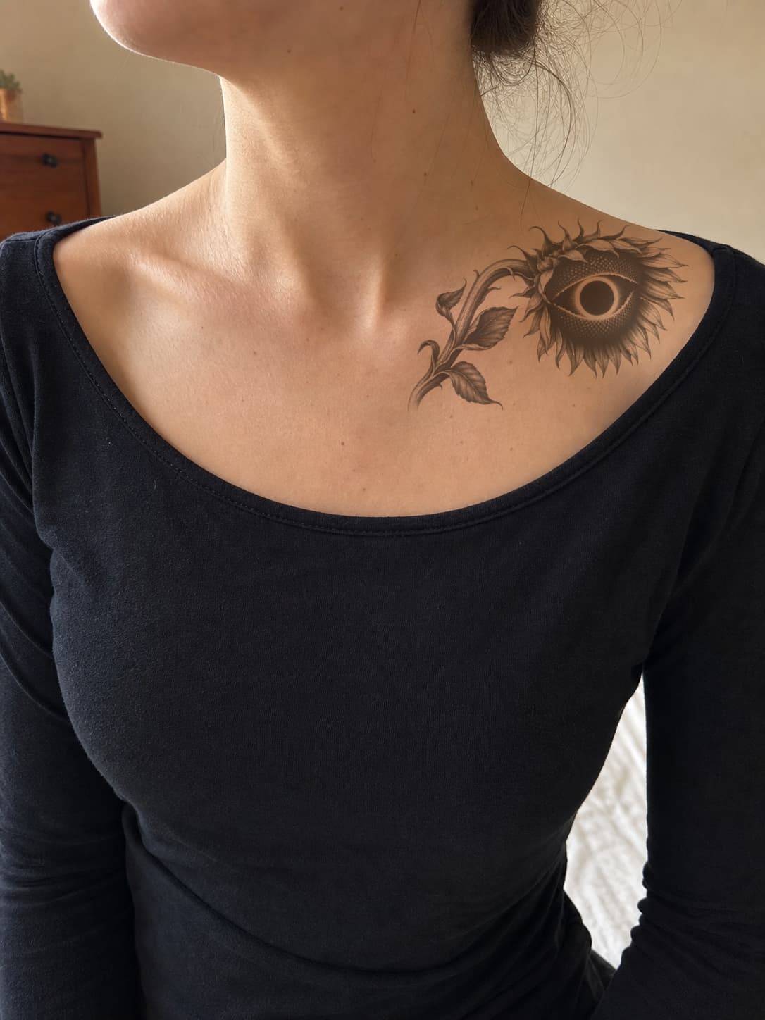 Sunflower eclipse tattoo preview placed across the upper chest near the collarbone